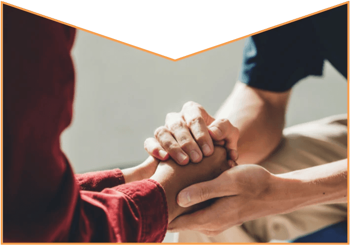 Two people clasping hands in a supportive gesture